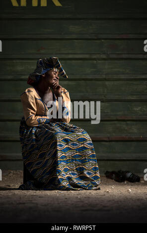 Die Herero Frau Rauch von außen ein Geschäft in Purros, Namibia. Stockfoto