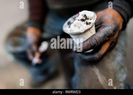 Eine kolumbianische Automechaniker hält einen Becher Eis während einer kurzen Pause im Barrio Triste, Medellín, Kolumbien. Stockfoto