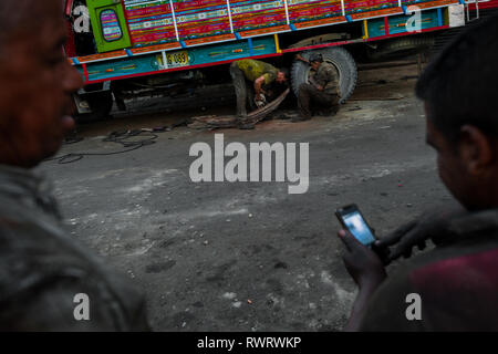 Kolumbianische Kfz-Mechaniker arbeiten am Fahrwerk ist ein Lkw in einer Autowerkstatt im Barrio Triste, Medellín, Kolumbien. Stockfoto