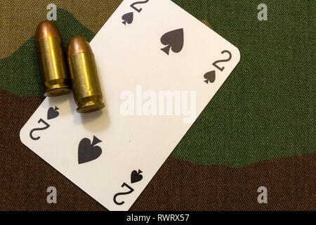 Zwei vintage Pistole Kugeln und Karte auf militärische Tarnung nahtlose Muster Hintergrund. Militärische glücksspiel Konzept. Stockfoto