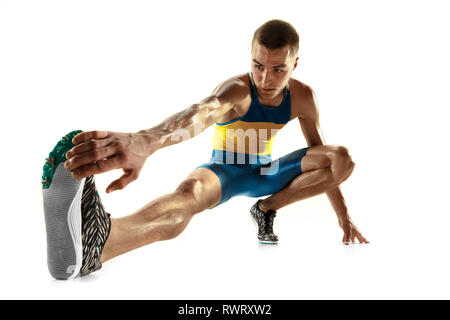 Jungen kaukasischen Mann Aufwärmen vor dem Laufen auf weiße studio Hintergrund isoliert. Eine männliche Läufer oder Jogger. Silhouette von Stretching Athlet mit Schatten. Stockfoto