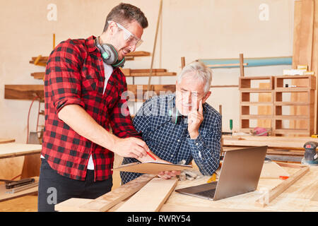 Zwei Handwerker mit Zwischenablage und Checkliste sind zusammen die Planung in der Schreinerei Stockfoto