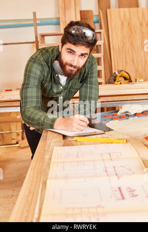 Junge Handwerker oder Architekten in der Planung mit einer Konstruktionszeichnung Stockfoto
