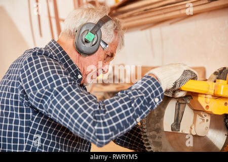 Alte Tischler Sägt Holz am Hacken sah in der Tischlerei oder Schreinerei Stockfoto