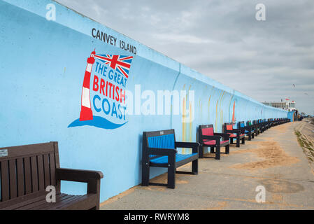 Küste des Vereinigten Königreichs am Meer, Blick auf Bänken entlang der blauen Meer Wand auf Canvey Island, Essex, England, Großbritannien Stockfoto