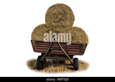Rundballen Stroh, mit einem Netz, auf einem Traktor Anhänger geladen. Stroh ist ein weit verbreitetes Material für Vieh Betten auf dem Bauernhof. Isoliert Foto. Stockfoto
