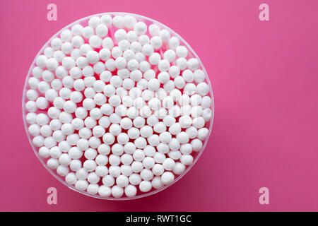 Detailansicht von oben auf runde Packung mit Wattestäbchen auf rosa Hintergrund. Stockfoto