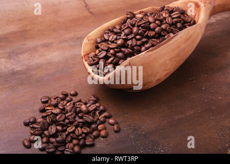 Alte hölzerne Schaufel mit Kaffeebohnen, Kaffeemühle und türkischen Kaffee in Cezve auf dunklen Tisch aus Stein. Stockfoto