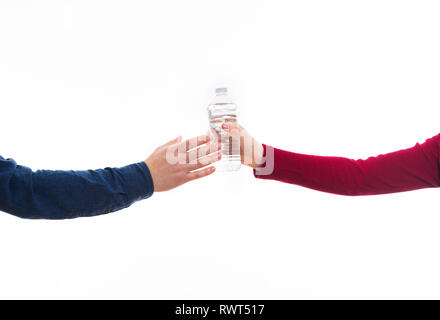 Nahaufnahme von Mann und Frau Hände geben eine Flasche frisches Trinkwasser isoliert auf Weiss. Hilfe einer durstigen Freund, der Partnerschaft und der Zusammenarbeit anhand von quantitativen Simulatio Stockfoto