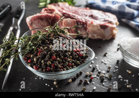 Vier Arten von Pfeffer würzen Erbsen in der Schüssel mit dem rohen Fleisch und Kräuter. Stockfoto