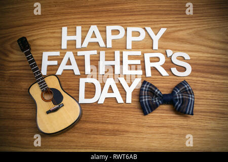 Happy Vatertag Briefe mit Gitarre auf Holz- Hintergrund. Ansicht von oben Stockfoto