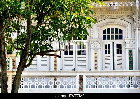 Vintage Rundbogenfenster mit antiken Fensterläden aus Holz und Stein Balkon auf Außen weiß von Singapur Peranaka Shophouse im historischen Little India Stockfoto