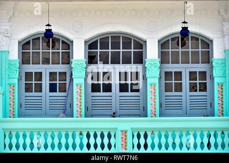Bunte vintage Windows mit antiken blauen Fensterläden aus Holz und Stein Balkon auf die weiße Fassade von Singapur Peranaka Shophouse in Little India Stockfoto