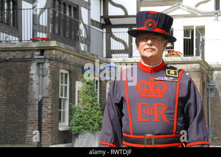 Einem Beefeater steht vor der Queens House im Tower von London. Es ist ein sonniger Tag und er ist auf der Hut Stockfoto