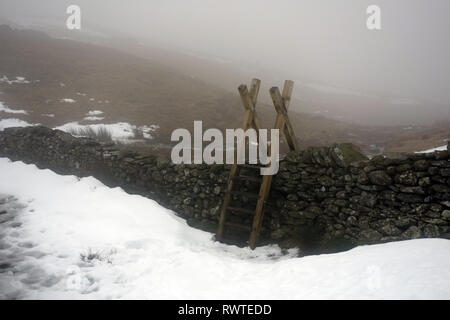 Die holzleiter Stil an der Spitze der Scandale Pass auf dem Weg zum Wainwright Rot Geröllhalden im Nationalpark Lake District, Cumbria, England, Großbritannien Stockfoto