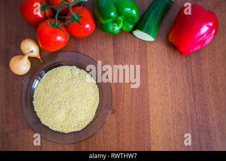 Frisches Gemüse und Couscous auf einem Holztisch vegane Mahlzeit zu kochen Stockfoto