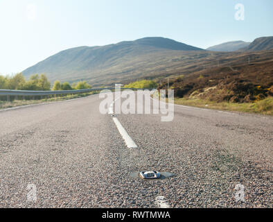 Land Straße windet sich durch die schottischen Highlands. UK. Fokus auf den Reflektor Trennlinie. Stockfoto