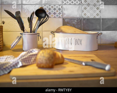 Brot und verschiedenen Küche Tools auf einem Küchentisch mit Rollen im Vordergrund. Stockfoto