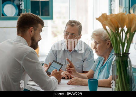 Senior Paar diskutiert mit Finanzberater zu Hause, um Fragen über Zukunft. Stockfoto