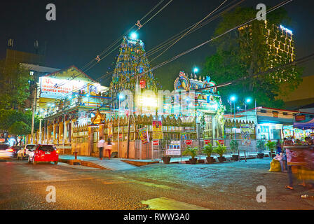 YANGON, MYANMAR - 15. FEBRUAR 2018: Die prunkvolle gopuram Turm erhebt sich über dem Sri Kaali Amman Hindu Tempel, beleuchtet mit hellen Abend Beleuchtung, Stockfoto