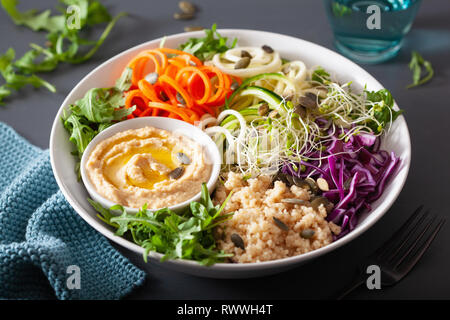 Veggie couscous Mittagessen Schüssel mit spiralazed Karotten und Zucchini, Hummus und Rotkohl Stockfoto