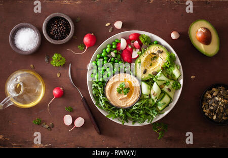 Gesund vegan Mittagessen Schüssel mit avocaco Gurke hummus Erbsen Rettich Stockfoto