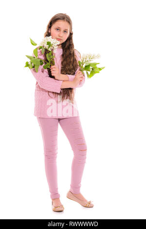 Mädchen 10-11 Jahre alt in einem rosa Anzug mit weißen Flieder in ihren Händen. Isolation auf weißem Hintergrund Stockfoto