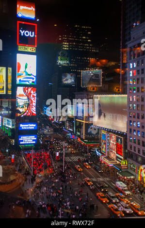 Helles Neon signage blinkt über Massen und taxi Datenverkehr, der an den Times Square der Veranstaltungsort der berühmten New. Stockfoto