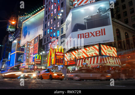 Helles Neon signage blinkt über Massen und taxi Datenverkehr, der an den Times Square der Veranstaltungsort der berühmten New. Mac Mc Donald's Times Square Ne Stockfoto