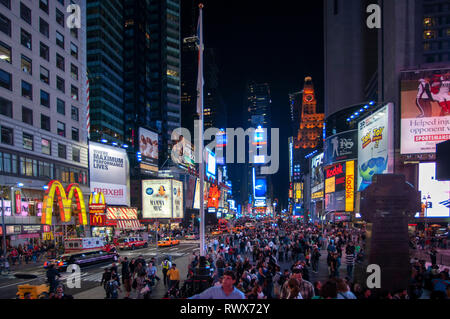 Helles Neon signage blinkt über Massen und taxi Datenverkehr, der an den Times Square der Veranstaltungsort der berühmten New. Mac Mc Donald's Times Square Ne Stockfoto