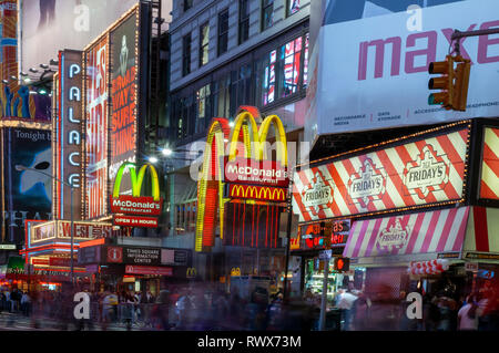 Helles Neon signage blinkt über Massen und taxi Datenverkehr, der an den Times Square der Veranstaltungsort der berühmten New. Mac Mc Donald's Times Square Ne Stockfoto