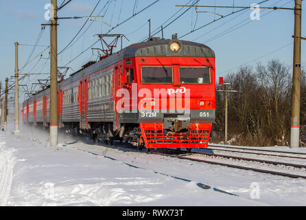 Russische Bahn im Winter. Der Zug fährt im Winter auf Schienen. ET2M051. Die Russische Bahn, Russland, Region Leningrad, Gatschina, 24. Februar 2018 Stockfoto
