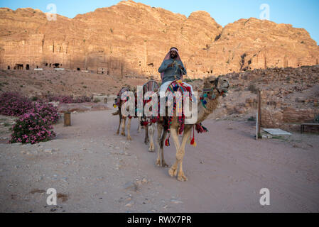 PETRA, Jordanien - 17. MAI 2018: Die arabischen Beduinen Führer reiten sein Kamel in das UNESCO-Weltkulturerbe von Petra Stockfoto