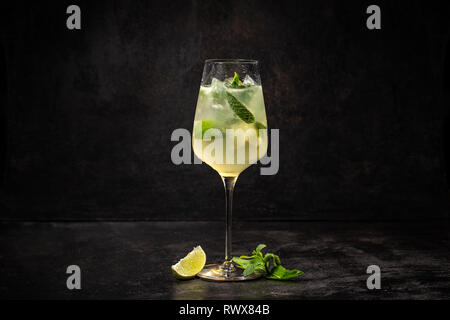 Sommer kaltes Getränk mit Zitrone, Minze und Eis auf schwarzem Hintergrund Stockfoto