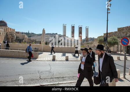 JERUSALEM, Israel - 16. MAI 2018: Haredi ultra-orthodoxe Juden wandern auf strees von Jerusalem, Ölberg im Hintergrund Stockfoto