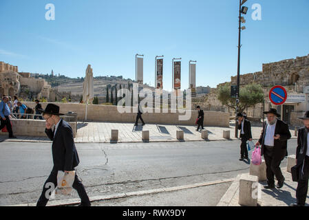 JERUSALEM, Israel - 16. MAI 2018: Haredi ultra-orthodoxe Juden wandern auf strees von Jerusalem, Ölberg im Hintergrund Stockfoto