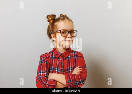 Porträt einer lustigen kleinen Vorschule kind Mädchen in Gläsern auf grauem Hintergrund. Bildung. Zurück zu Schule. Stockfoto