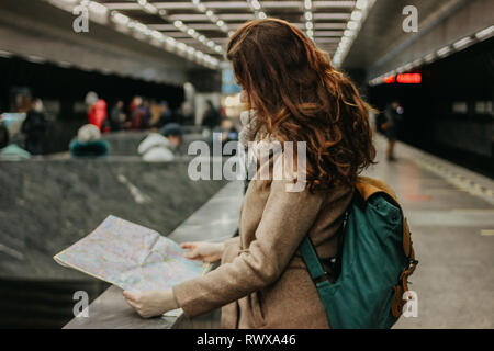 Junge Frau curly red head girl Reisenden mit Rucksack und Karte in der Nähe der U-Bahn Stockfoto