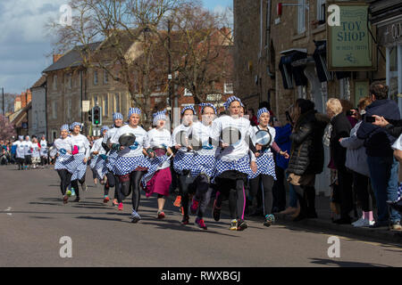 Bild vom 5. März zeigt das Weltälteste Pfannkuchen Rennen auf den Straßen von Olney, Bucks, am Dienstag Morgen. Mehr als 2000 Menschen auf den Straßen von Olney, Buckinghamshire zu 25 Townswomen fahren sehen, gekleidet wie Hausfrauen, konkurrieren in der ältesten Pancake race in der Welt von heute (Dienstag). Die Frauen trugen Röcke, Schürzen und Kopftüchern, wie sie lief mit skillets und Pfannkuchen, um die Ziellinie in der 574 Jahre alten Rasse in der kleinen Marktstadt. Die historische Faschingsdienstag Rennen, das im Jahr 1445 gestartet, ist offen für Frauen über 18, die in der malerischen Stadt für mehr als drei gelebt haben Stockfoto