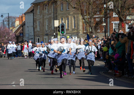 Bild vom 5. März zeigt das Weltälteste Pfannkuchen Rennen auf den Straßen von Olney, Bucks, am Dienstag Morgen. Mehr als 2000 Menschen auf den Straßen von Olney, Buckinghamshire zu 25 Townswomen fahren sehen, gekleidet wie Hausfrauen, konkurrieren in der ältesten Pancake race in der Welt von heute (Dienstag). Die Frauen trugen Röcke, Schürzen und Kopftüchern, wie sie lief mit skillets und Pfannkuchen, um die Ziellinie in der 574 Jahre alten Rasse in der kleinen Marktstadt. Die historische Faschingsdienstag Rennen, das im Jahr 1445 gestartet, ist offen für Frauen über 18, die in der malerischen Stadt für mehr als drei gelebt haben Stockfoto