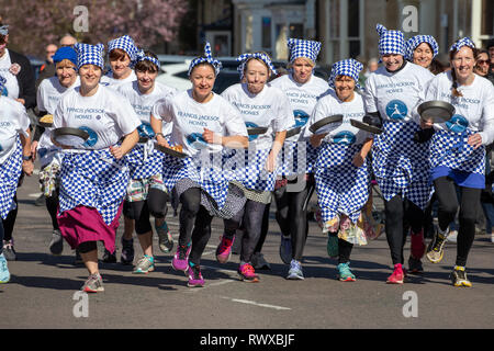 Bild vom 5. März zeigt das Weltälteste Pfannkuchen Rennen auf den Straßen von Olney, Bucks, am Dienstag Morgen. Mehr als 2000 Menschen auf den Straßen von Olney, Buckinghamshire zu 25 Townswomen fahren sehen, gekleidet wie Hausfrauen, konkurrieren in der ältesten Pancake race in der Welt von heute (Dienstag). Die Frauen trugen Röcke, Schürzen und Kopftüchern, wie sie lief mit skillets und Pfannkuchen, um die Ziellinie in der 574 Jahre alten Rasse in der kleinen Marktstadt. Die historische Faschingsdienstag Rennen, das im Jahr 1445 gestartet, ist offen für Frauen über 18, die in der malerischen Stadt für mehr als drei gelebt haben Stockfoto