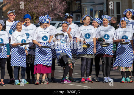 Bild vom 5. März zeigt das Weltälteste Pfannkuchen Rennen auf den Straßen von Olney, Bucks, am Dienstag Morgen. Mehr als 2000 Menschen auf den Straßen von Olney, Buckinghamshire zu 25 Townswomen fahren sehen, gekleidet wie Hausfrauen, konkurrieren in der ältesten Pancake race in der Welt von heute (Dienstag). Die Frauen trugen Röcke, Schürzen und Kopftüchern, wie sie lief mit skillets und Pfannkuchen, um die Ziellinie in der 574 Jahre alten Rasse in der kleinen Marktstadt. Die historische Faschingsdienstag Rennen, das im Jahr 1445 gestartet, ist offen für Frauen über 18, die in der malerischen Stadt für mehr als drei gelebt haben Stockfoto