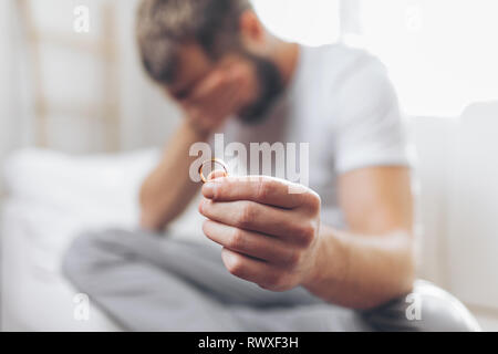 Mit gebrochenem Herzen Mann zu Hause eine Hochzeit Ring Stockfoto