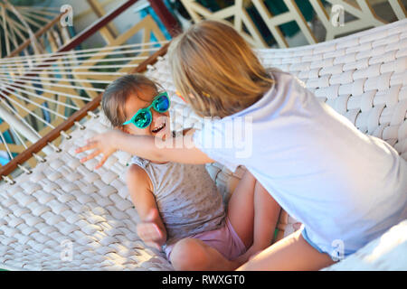 Zwei kleine glückliche Mädchen spielen auf Hängematte im Sommer Tag Stockfoto