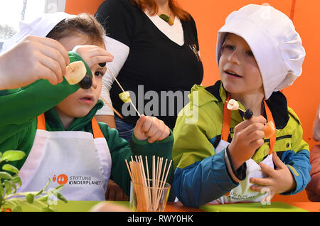 07 März 2019, Thüringen, Erfurt: Kinder aus dem 'Anne Frank' Kindergarten in Weimar vorbereiten Fruchtspieße während der Präsentation von "Julchens Kochmobil' durch den Kinderplanet Stiftung. Die kochen Mobile ist mit einem Haushalt Küche und eine Arbeitsfläche, wo die Kinder ihr eigenes Essen unter der Leitung von Koch selbst zubereiten können. Foto: Martin Schutt/dpa-Zentralbild/dpa Stockfoto