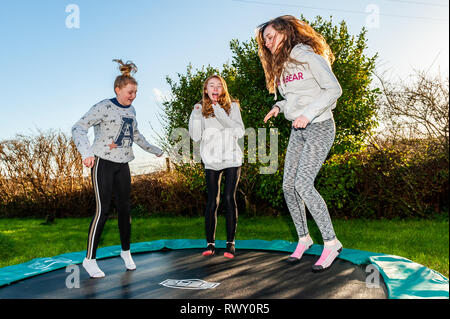 Ballydehob, West Cork, Irland. März 2019, 7th. Mädchen machen das Beste aus dem heißen, sonnigen Wetter, indem sie auf einem Trampolin hüpfen. Der Tag wird weiterhin sonnig sein, während der Morgen trocken beginnt mit Schauern am Nachmittag. Quelle: AG News/Alamy Live News. Stockfoto