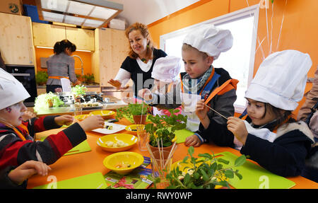 Erfurt, Deutschland. 07 Mär, 2019. Kerstin Ullrich (M) von der Kochschule "Iss' bereitet Fruchtspieße mit Kindern aus dem Kindergarten Johannesplatz in Erfurt bei der Vorstellung von "Julchens Kochmobil' durch den Kinderplanet Stiftung. Die kochen Mobile ist mit einem Haushalt Küche und eine Arbeitsfläche, wo die Kinder ihr eigenes Essen unter der Leitung von Koch selbst zubereiten können. Foto: Martin Schutt/dpa-Zentralbild/dpa/Alamy leben Nachrichten Stockfoto