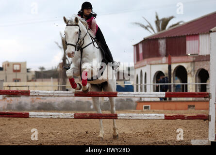 Gaza Stadt. 7 Mär, 2019. Eine palästinensische Mädchen reitet ein Pferd während ein Reitzentrum Training Session in Gaza Stadt, am 7. März 2019. Pferdesport in Gaza zieht junge Menschen als eine Art von Unterhaltung. Credit: Yasser Qudih/Xinhua/Alamy leben Nachrichten Stockfoto