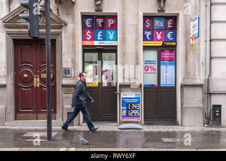 Peking, China. 6 Mär, 2019. Ein Mann geht über eine Wechselstube Shop in der Nähe der Bank von England in London, 6. März 2019. Da Großbritannien in der Europäischen Union (EU) am 29. März lassen, UK Finance Unternehmen wurden die Vorbereitung für eine "no-deal" Szenario, dass Sie glauben, dass 'katastrophal' für die Wirtschaft der Nation sein. Credit: Stephen Chung/Xinhua/Alamy leben Nachrichten Stockfoto