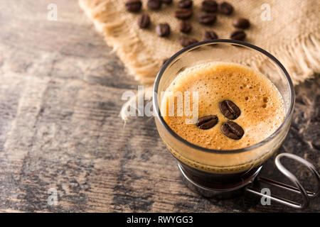 Kaffee Glas und Kaffee Korn auf Holztisch. Copyspace Stockfoto